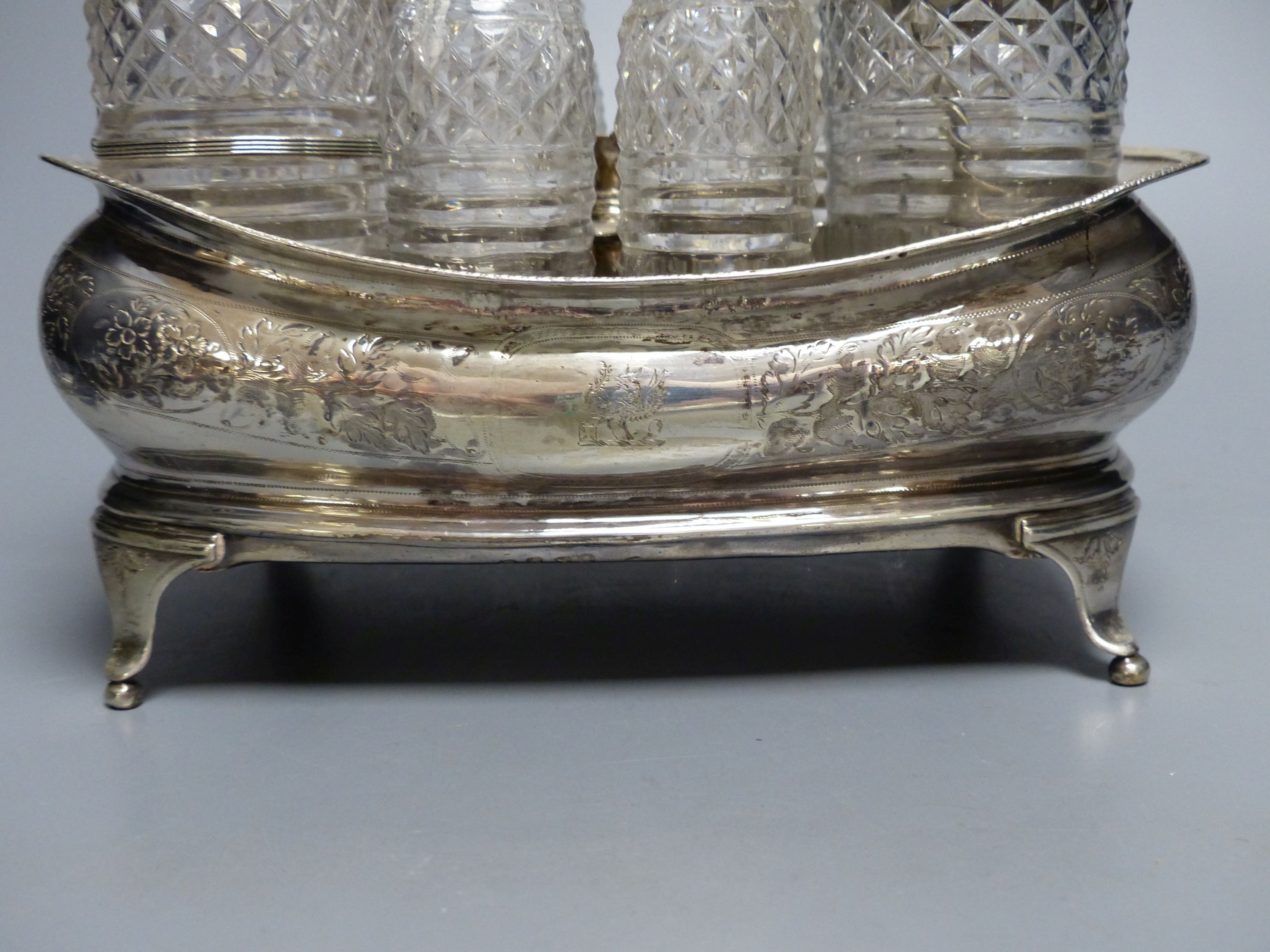 A George III silver cruet stand, with six matching cruets, London 1808, and two associated cruets, handle missing,